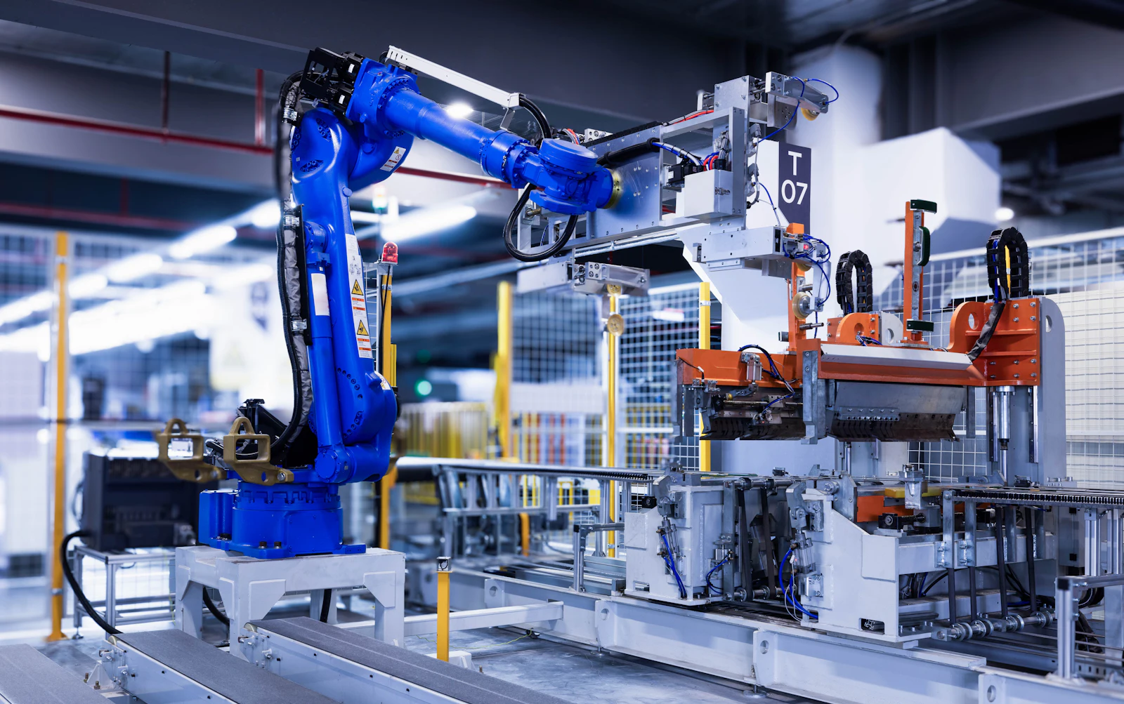 A blue industrial robot arm working on a factory production line